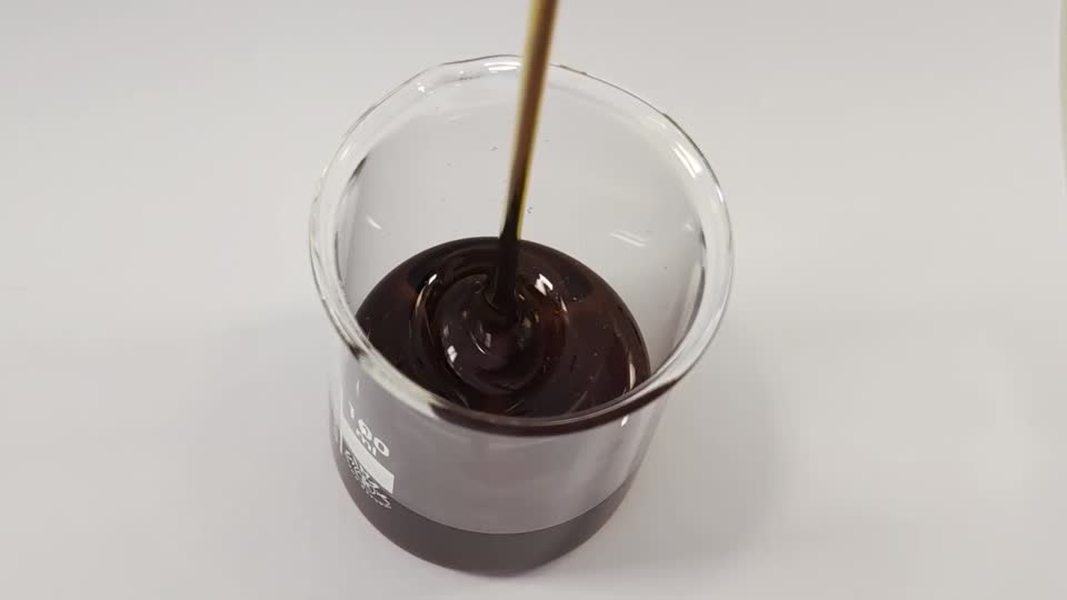 Dark sugar syrup being poured into a beaker during sample preparation