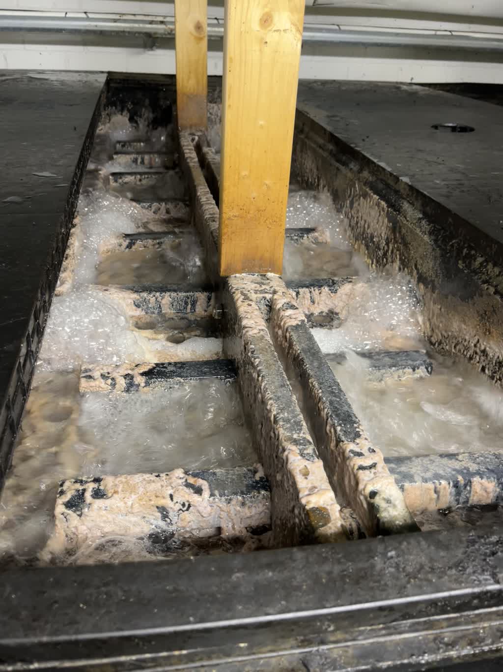 Aerated wastewater flowing through a channel with weir boards at Castellet Bruk